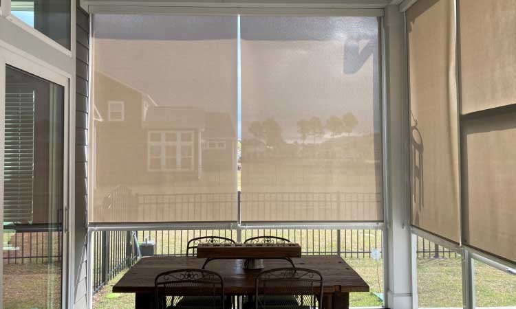 Covered patio with sheers blinds with a rustic table and chairs